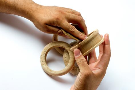 Le créateur de bijoux Alfonso Mendoca travaillant le bois servant à la création des bracelets